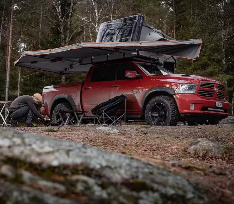 Dodge Ram rosso con tenda da tetto e tendalino grigio