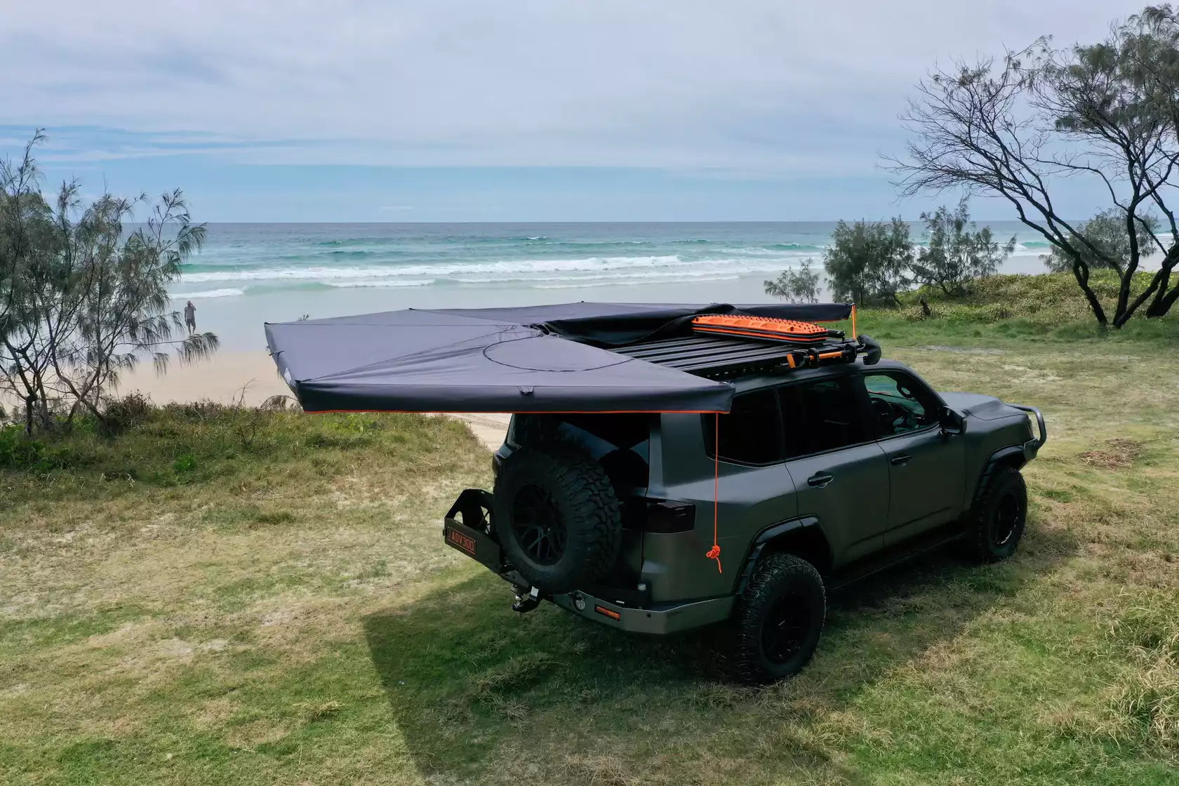 Tenda circolare nera e arancione ripiegata a sinistra di una 4x4