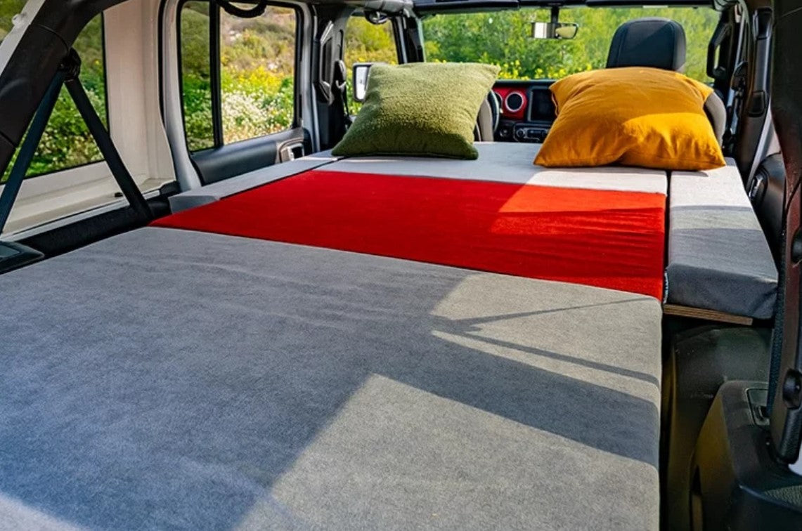 materasso grigio e rosso in un furgone con 2 cuscini