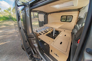 interno di un furgone con disposizione di letto e tavolo