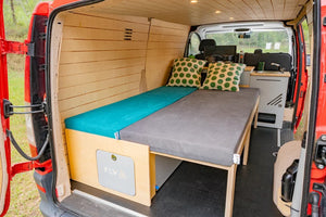 allestita in legno in un van rosso con il letto dispiegato