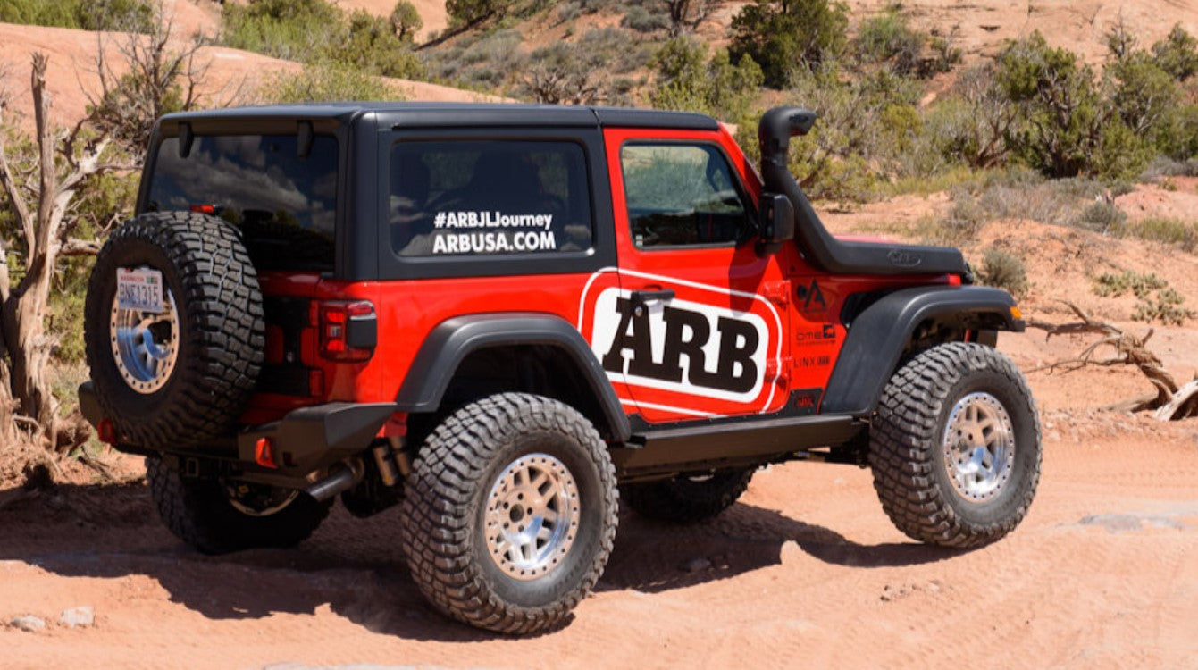 Jeep wrangler JL rossa nel deserto con un grande logo ARB