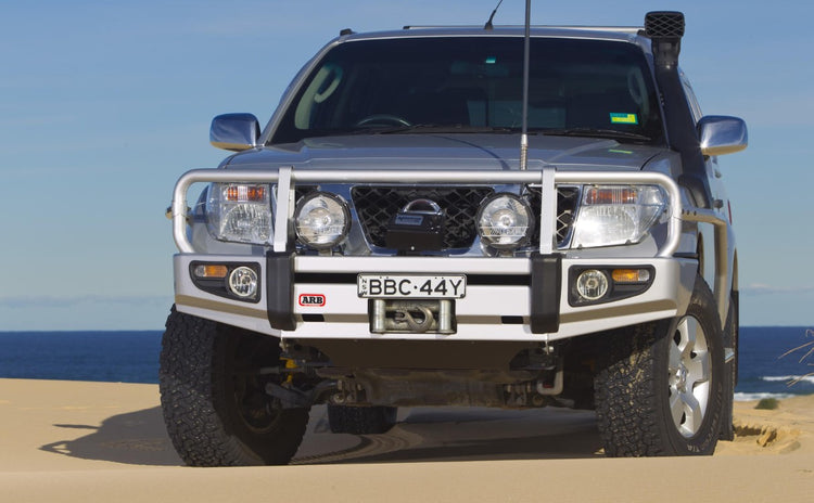 Nissan Pathfinder R51 grigio nel deserto con un paraurti ARB