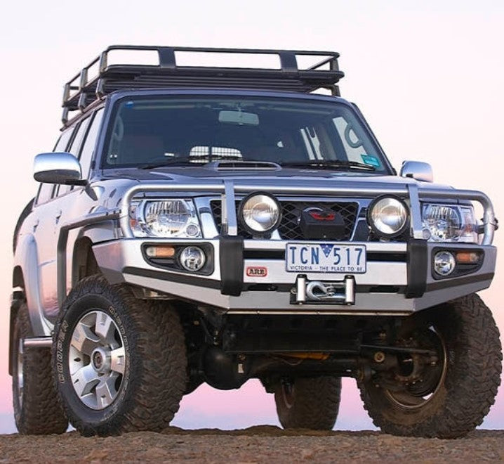 Nissan Patrol Y61 su una roccia con portapacchi e paraurti