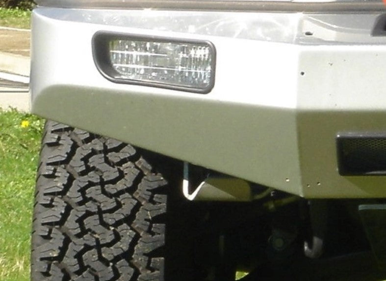 Vista frontale di un veicolo con un pneumatico e un faro fendinebbia