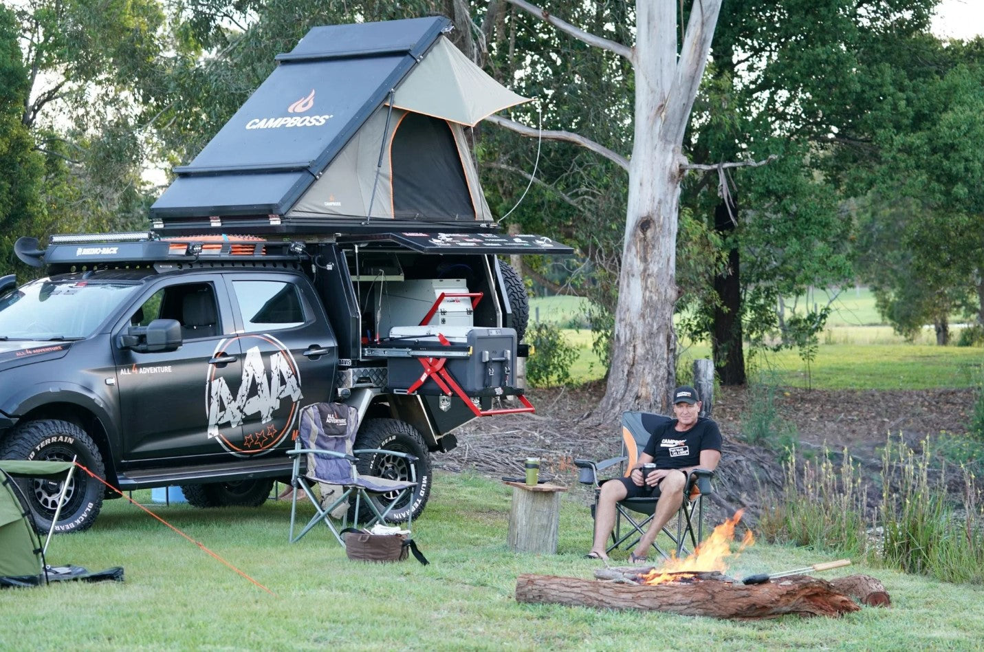 Un uomo che si gode il suo spazio in campeggio con la sua 4x4 e una tenda da tetto rigida in alluminio Campboss