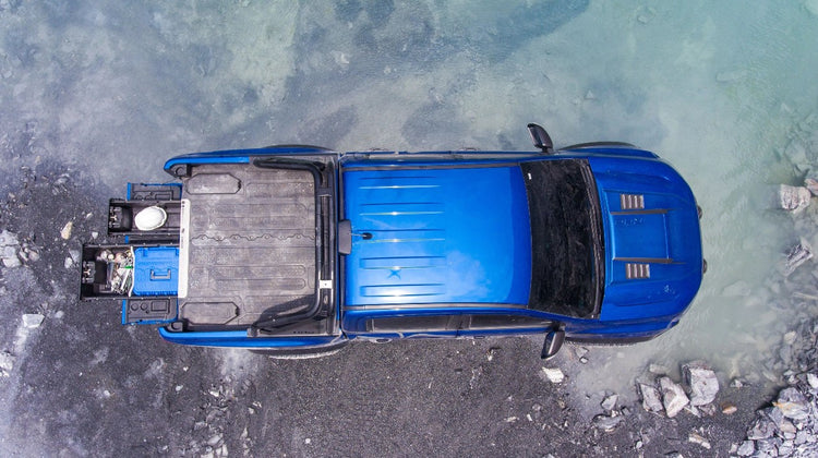 vista dall'alto di un pick-up blu con un cassetto aperto sul davanti Cassone