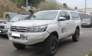 Toyota Hilux bianco parcheggiato con uno snorkel e un PC in acciaio