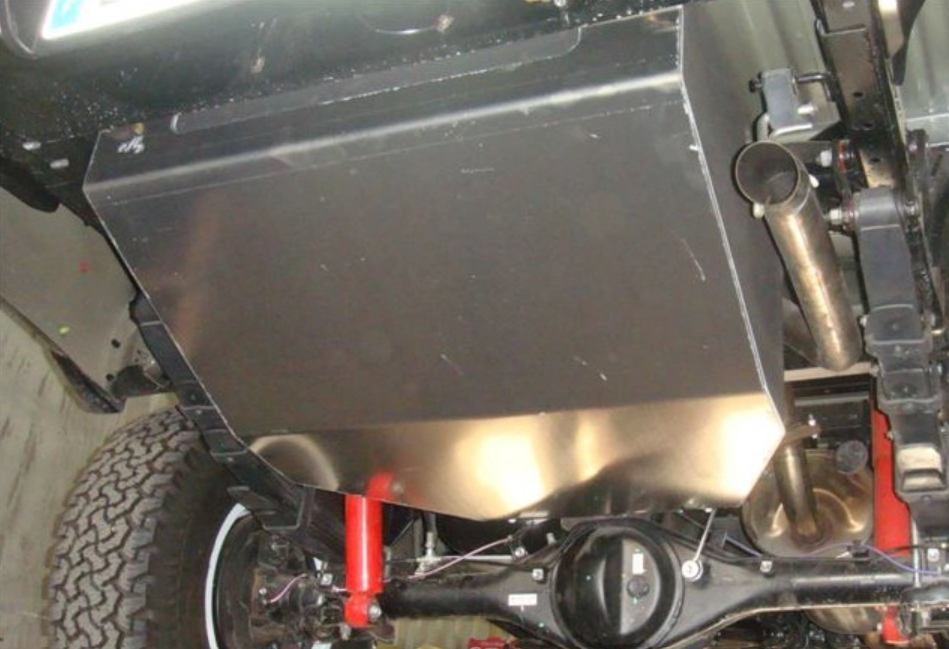serbatoio in acciaio montato sotto un veicolo con ammortizzatori rossi