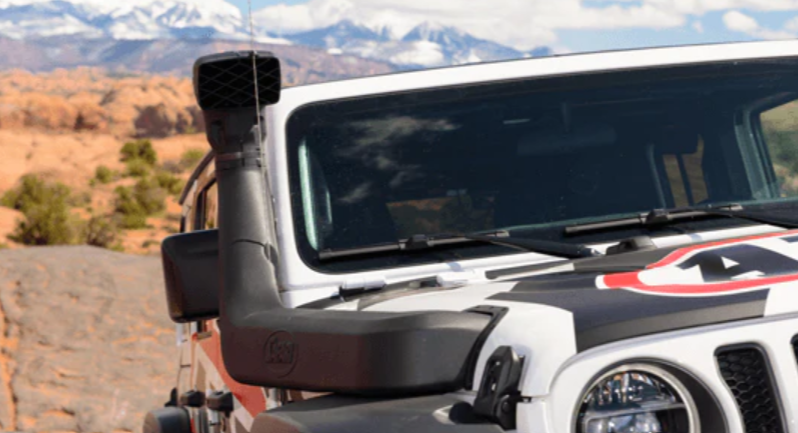 vista frontale di una jeep con un boccaglio e un paesaggio montano