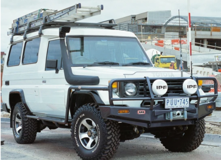 Land Cruiser 76 bianco con snorkel e scala sul portatutto